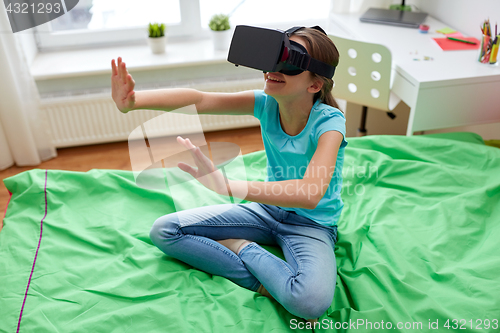 Image of happy girl in vr headset or 3d glasses at home