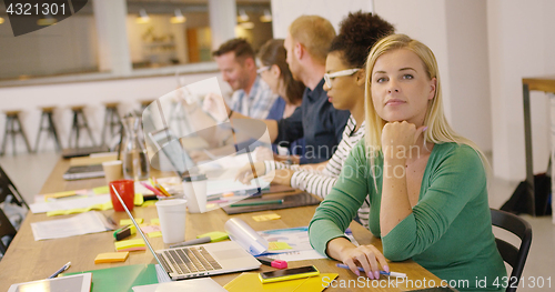 Image of Woman posing contently in office