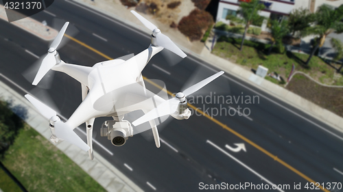 Image of Unmanned Aircraft System (UAV) Quadcopter Drone In The Air Over 