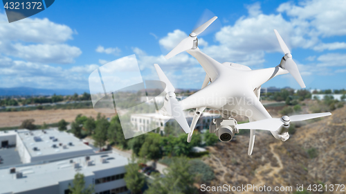 Image of Unmanned Aircraft System (UAV) Quadcopter Drone In The Air Over 