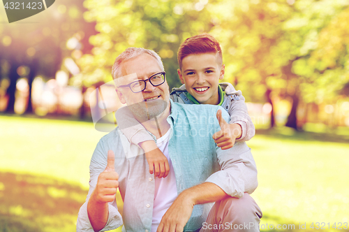 Image of grandfather and boy showing thumbs up at summer