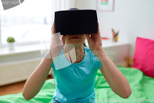 Image of happy girl in vr headset or 3d glasses at home