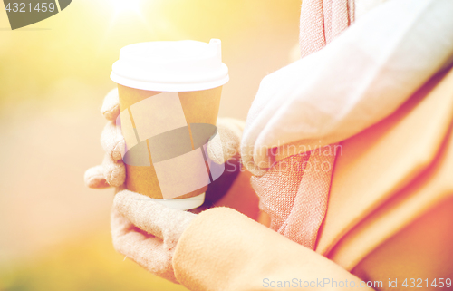 Image of close up of woman with coffee in autumn park