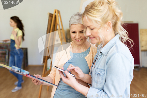 Image of artists with smartphone painting at art school