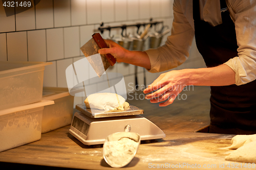 Image of chef or baker weighing dough on scale at bakery