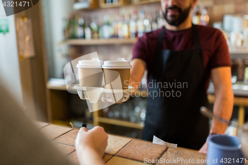 Image of man or bartender serving customer at coffee shop