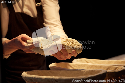 Image of baker with dough rising in baskets at bakery