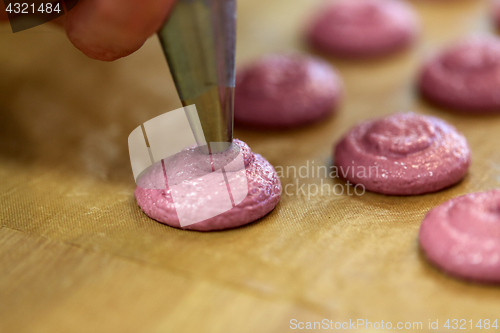 Image of chef with nozzle squeezing macaron batter