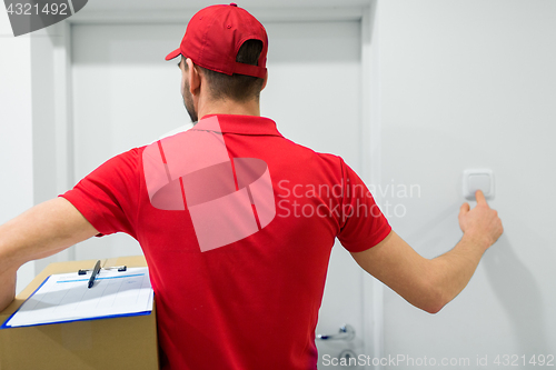 Image of delivery man with parcel box ringing door bell