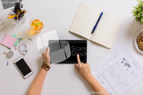 Image of hands with tablet pc and notebook at office table