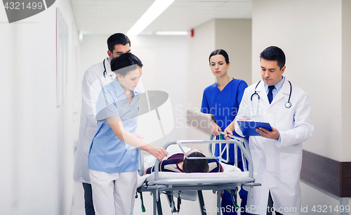 Image of medics with woman on hospital gurney at emergency