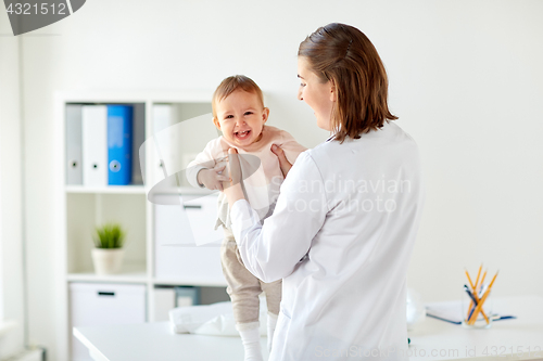 Image of doctor or pediatrician holding baby at clinic