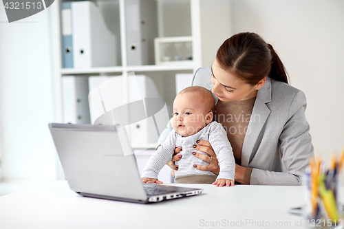 Image of happy businesswoman with baby and laptop at office