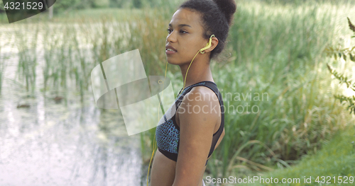 Image of Dreaming sportswoman posing on lakeside