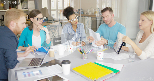 Image of Woman showing documents to coworkers