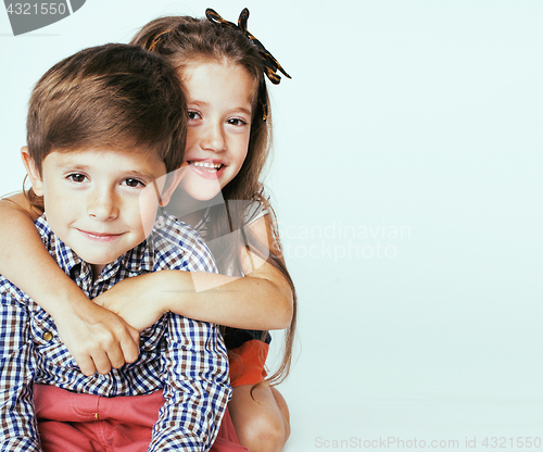 Image of little cute boy and girl hugging playing on white background, ha