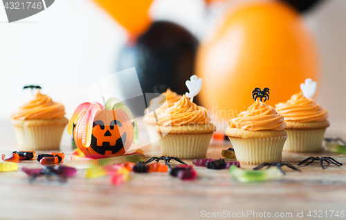 Image of halloween party decorated cupcakes on wooden table