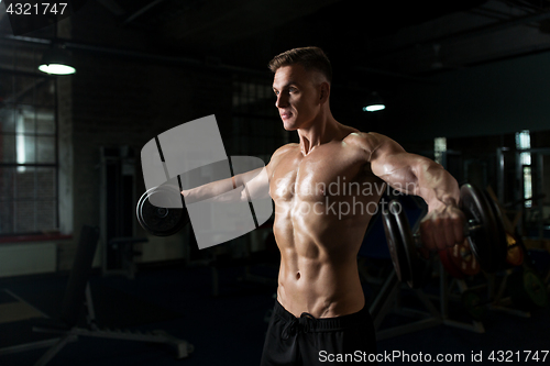 Image of close up of man with dumbbells exercising in gym