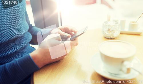 Image of close up of man with smartphones at cafe