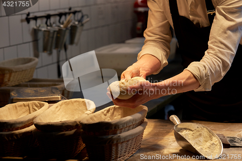 Image of baker with dough rising in baskets at bakery