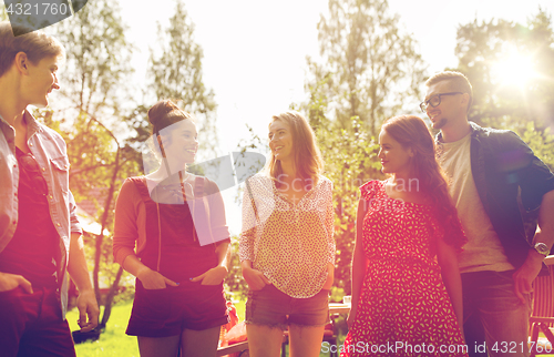 Image of happy teenage friends talking at summer garden