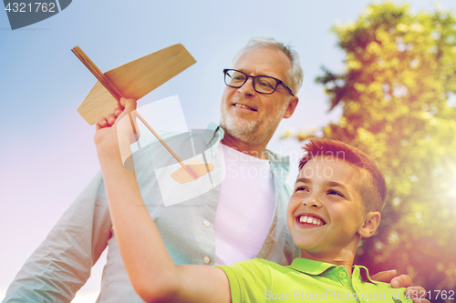 Image of senior man and boy with toy airplane over sky