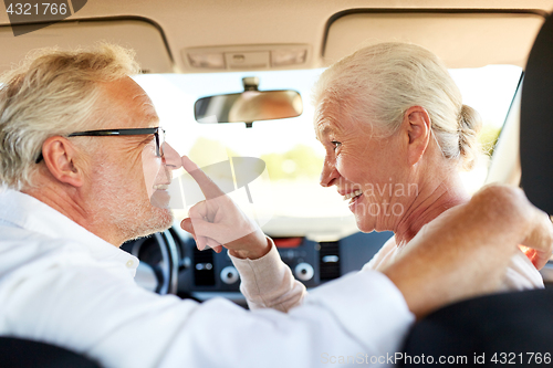 Image of happy senior couple driving in car