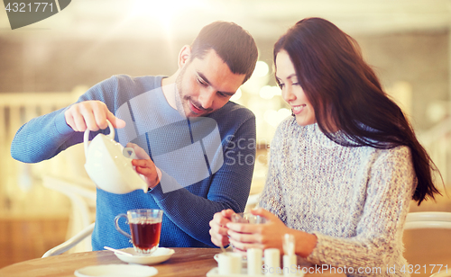 Image of happy couple drinking tea at cafe