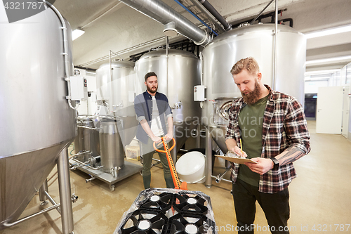 Image of men with beer kegs on loader at craft brewery