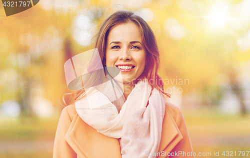 Image of beautiful happy young woman smiling in autumn park