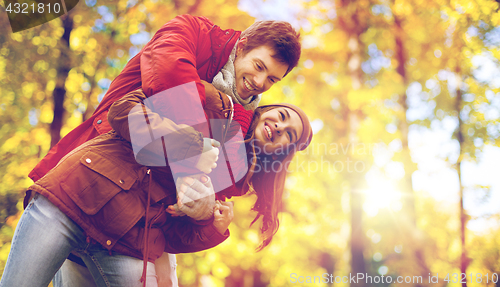 Image of happy young couple having fun in autumn park