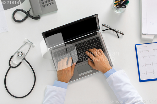 Image of doctor hands typing on laptop at clinic