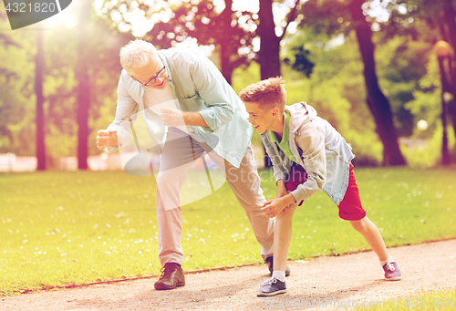 Image of grandfather and grandson racing at summer park