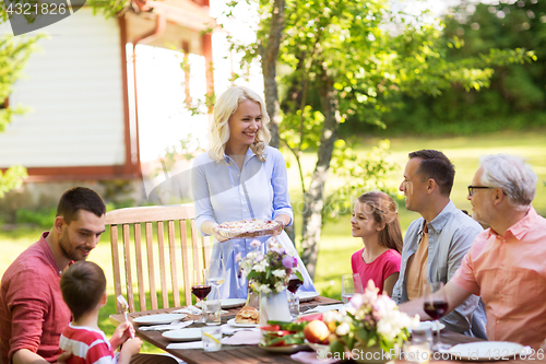 Image of happy family having dinner or summer garden party