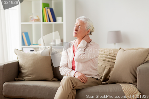 Image of senior woman suffering from neck pain at home