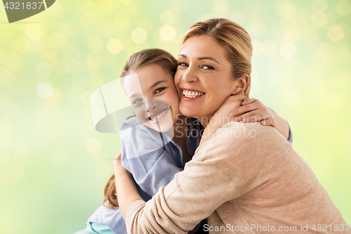 Image of happy girl with mother hugging over lights