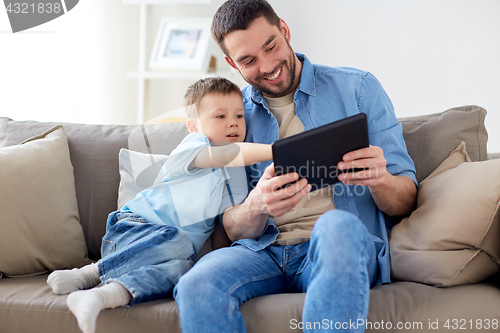 Image of father and son with tablet pc playing at home