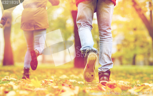 Image of young couple running in autumn park