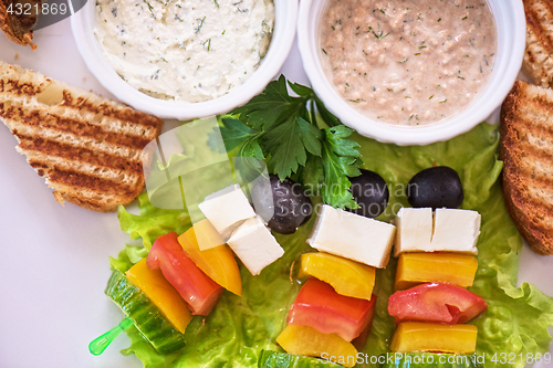 Image of toast with cheese vegetables and olive on the stick