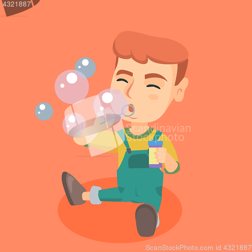 Image of Little caucasian boy blowing soap bubbles.