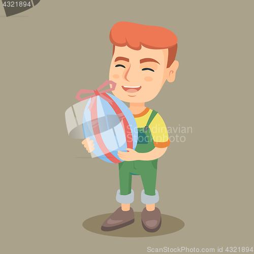 Image of Little caucasian boy holding a painted easter egg.