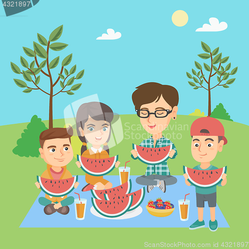 Image of Mother with kids eating watermelon at the park.