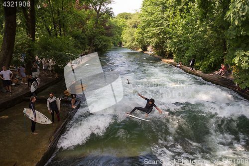 Image of Surfer surfing an artificial wave in Munich city center, Germany.