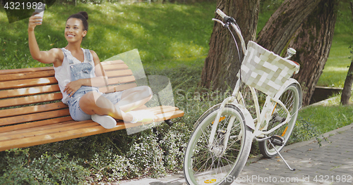 Image of Cheerful model taking selfie in park