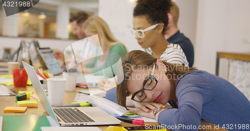 Image of Employee sleeping at table with coworkers