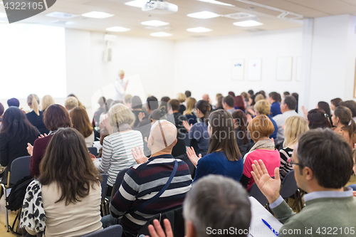 Image of Woman giving interactive motivational speech at entrepreneurship workshop.