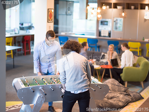 Image of Office People Enjoying Table Soccer Game