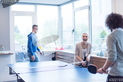 Image of startup business team playing ping pong tennis