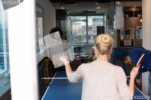 Image of startup business team playing ping pong tennis