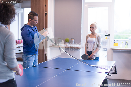 Image of startup business team playing ping pong tennis